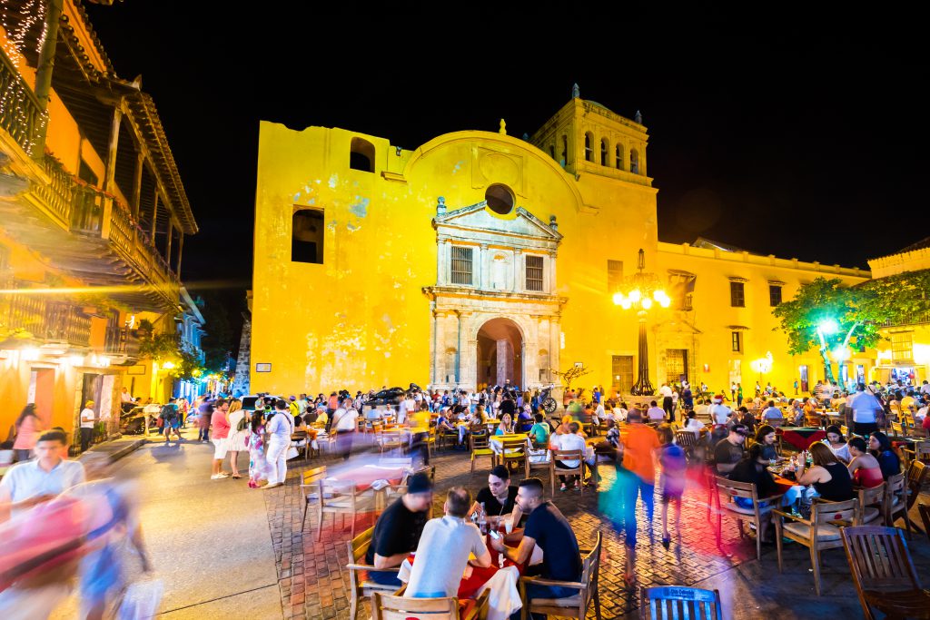 Cartagena, Colombia - December 19, 2014: People fillip up the seats in Plaza Santo Domingo, a plaza popular among locals and tourists in Cartagena, Colombia.